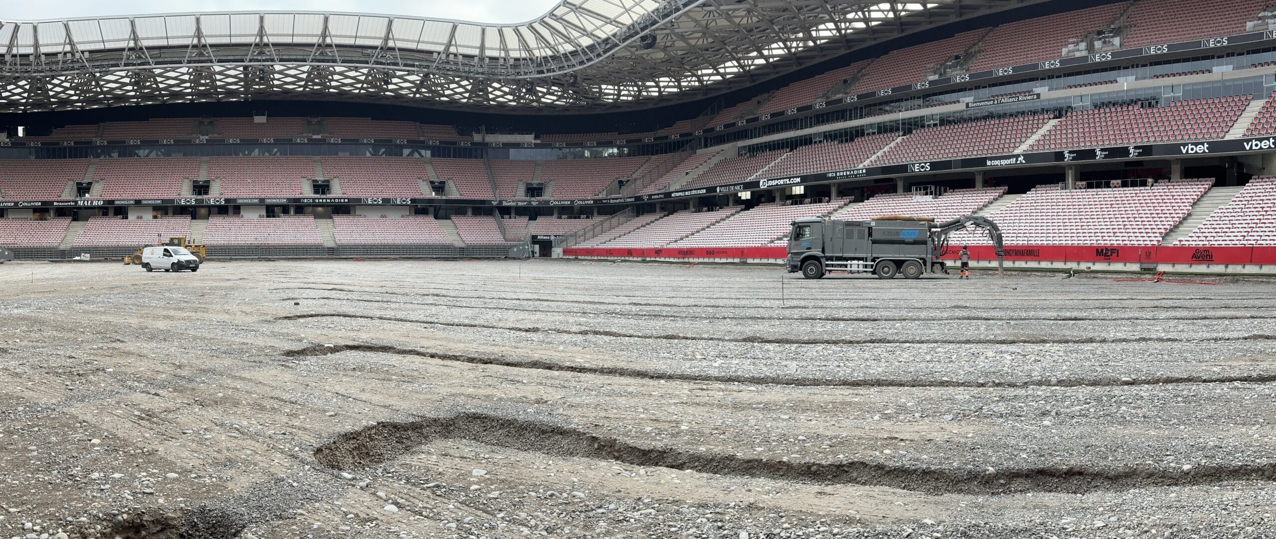 Chantier de rénovation du terrain à l'Allianz Riviera de Nice avec camion AZUR ASPI sur sol en graviers.